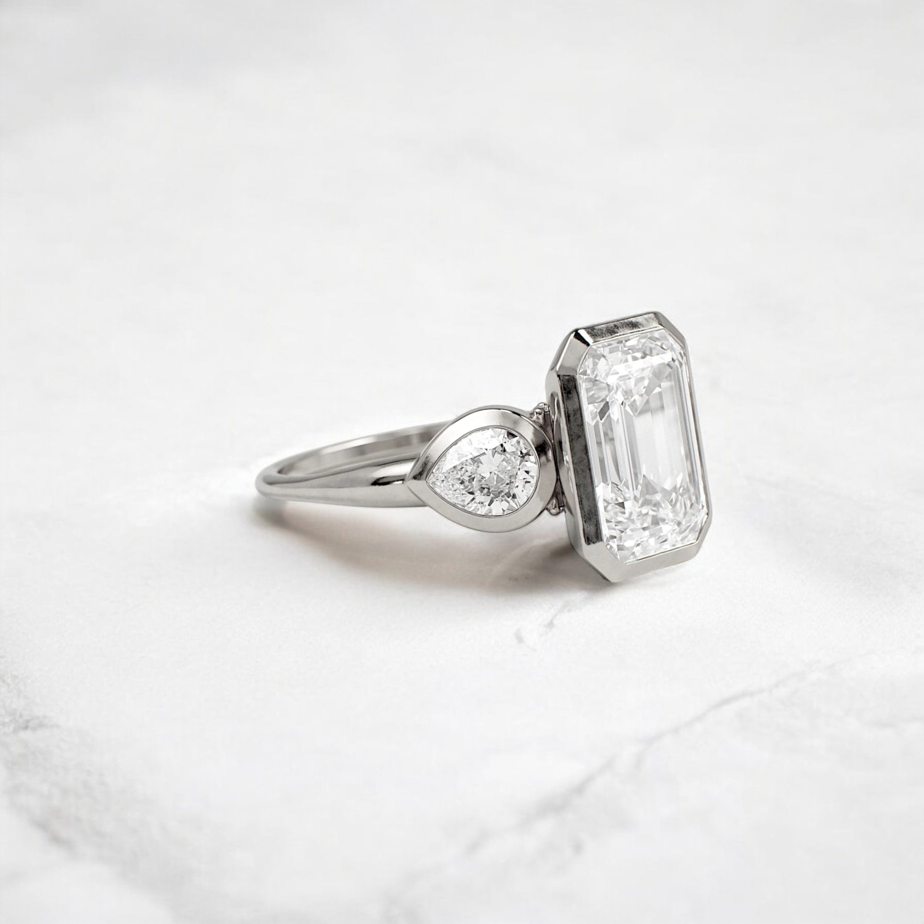 bezel-emerald-moissanite-engagement-ring-pear-side-sparkle-stones-3-ct-platinum-gemfora-2
