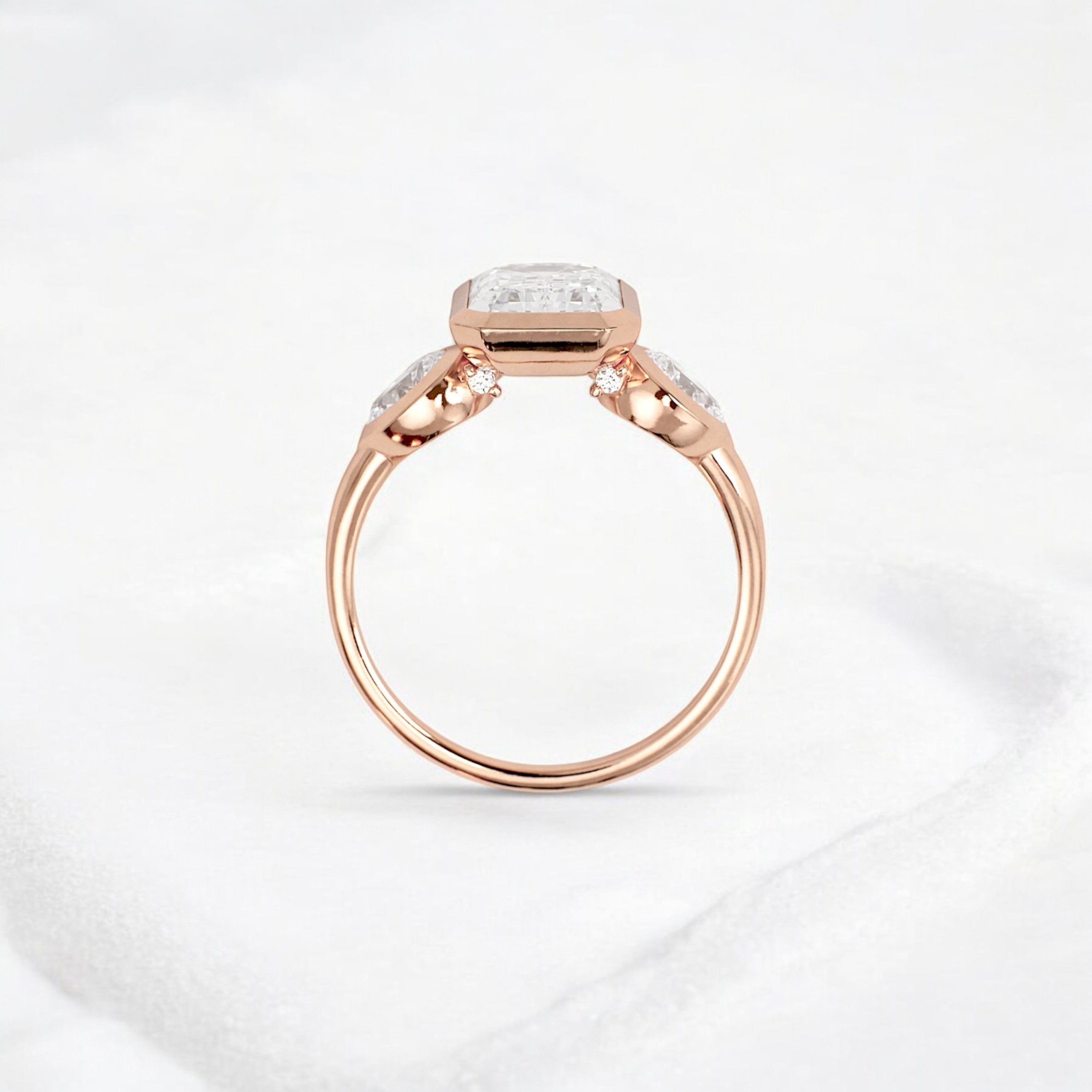 bezel-emerald-moissanite-engagement-ring-pear-side-sparkle-stones-3-ct-rose-gold-gemfora-4