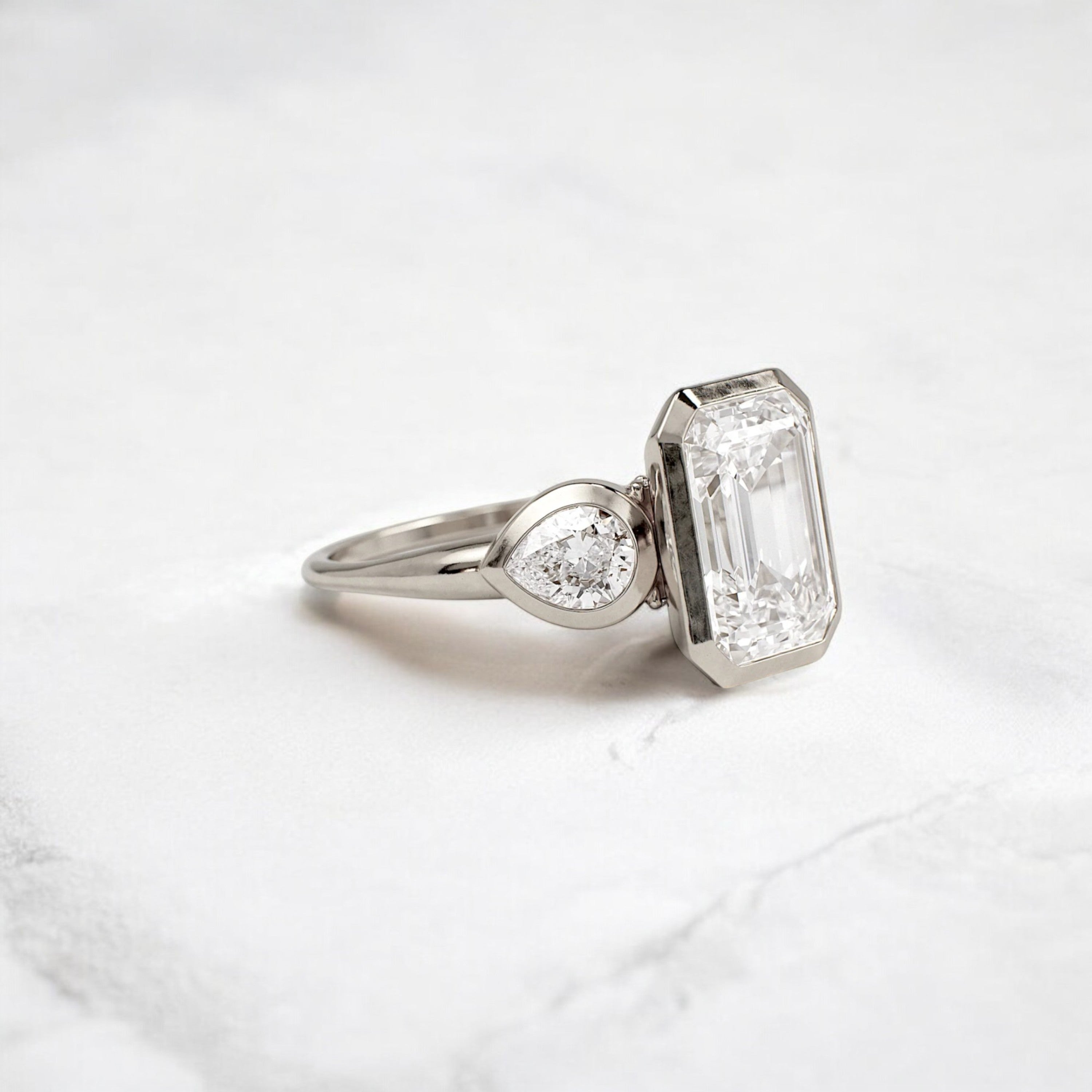 bezel-emerald-moissanite-engagement-ring-pear-side-sparkle-stones-3-ct-white-gold-gemfora-2