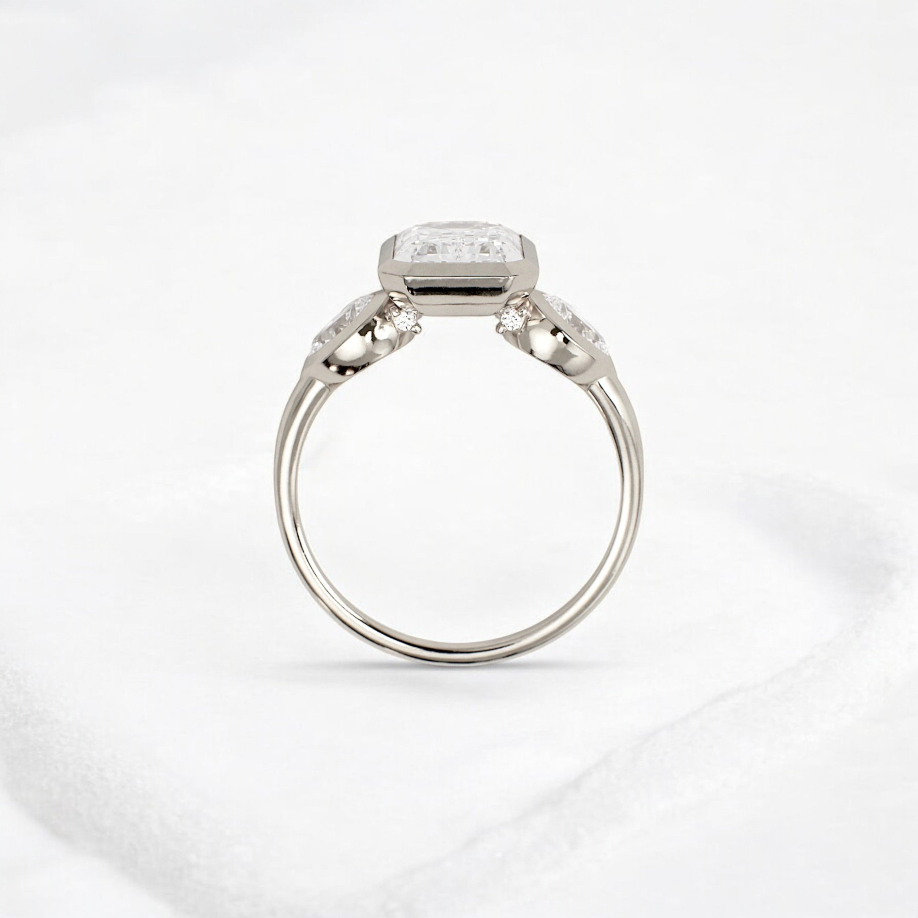 bezel-emerald-moissanite-engagement-ring-pear-side-sparkle-stones-3-ct-white-gold-gemfora-4