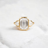 bezel-emerald-moissanite-engagement-ring-pear-side-sparkle-stones-3-ct-yellow-gold-gemfora-1