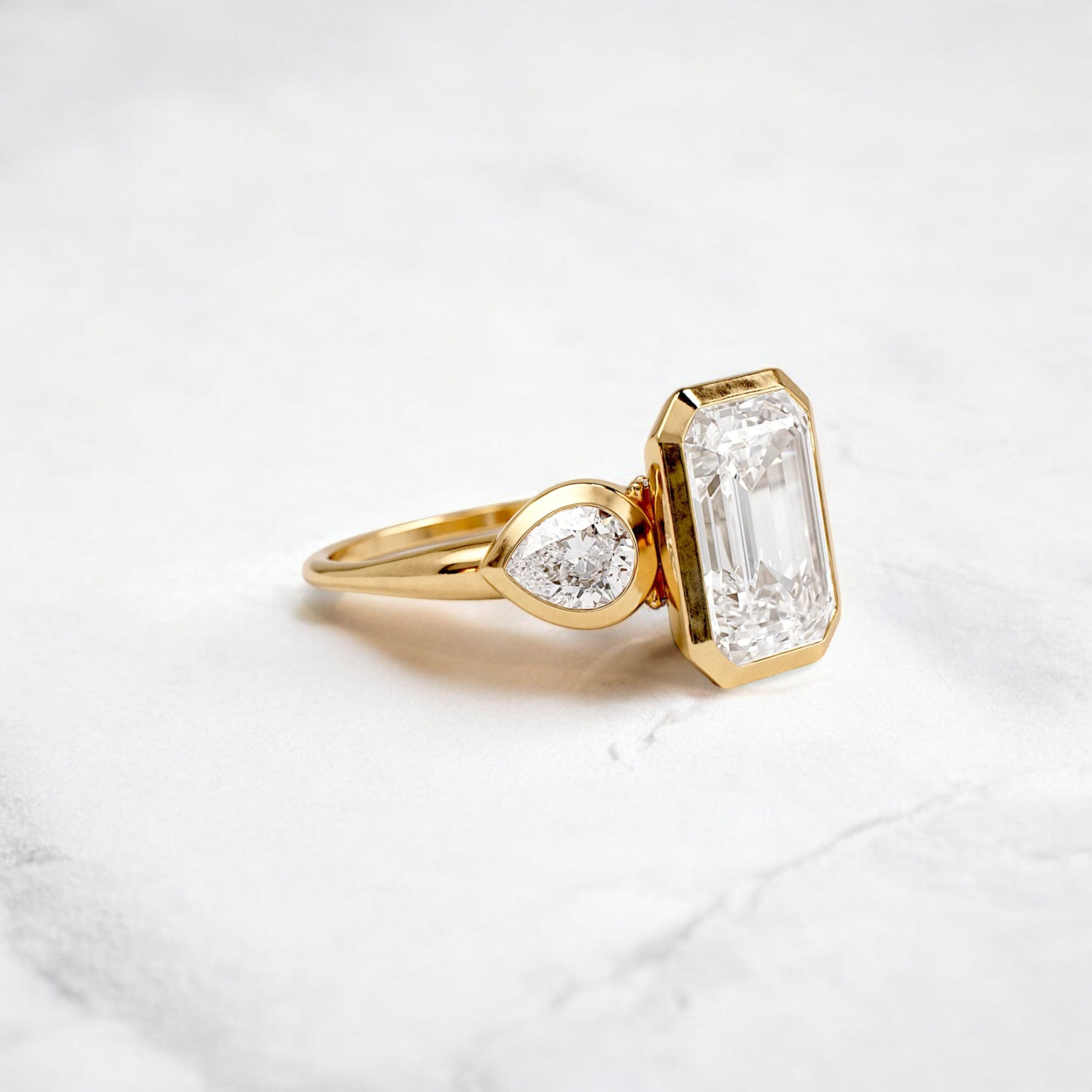 bezel-emerald-moissanite-engagement-ring-pear-side-sparkle-stones-3-ct-yellow-gold-gemfora-2