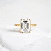 emerald-cut-engagement-ring-classic-crossed-moissanite-band-4-ct-yellow-gold-gemfora-1