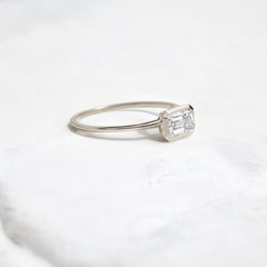Elegant handmade emerald cut diamond engagement ring, featuring a bezel setting designed for women.