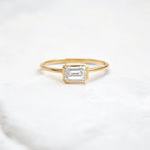 Elegant handmade emerald cut diamond engagement ring, featuring a bezel setting designed for women.