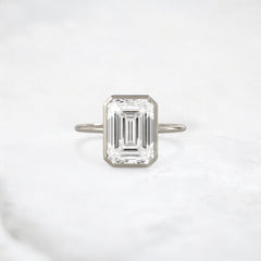 secret-glimmer-emerald-cut-bezel-moissanite-engagement-ring-4-ct-white-gold-gemfora-1