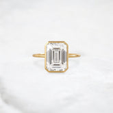 secret-glimmer-emerald-cut-bezel-moissanite-engagement-ring-4-ct-yellow-gold-gemfora-1