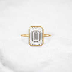 secret-glimmer-emerald-cut-bezel-moissanite-engagement-ring-4-ct-yellow-gold-gemfora-1