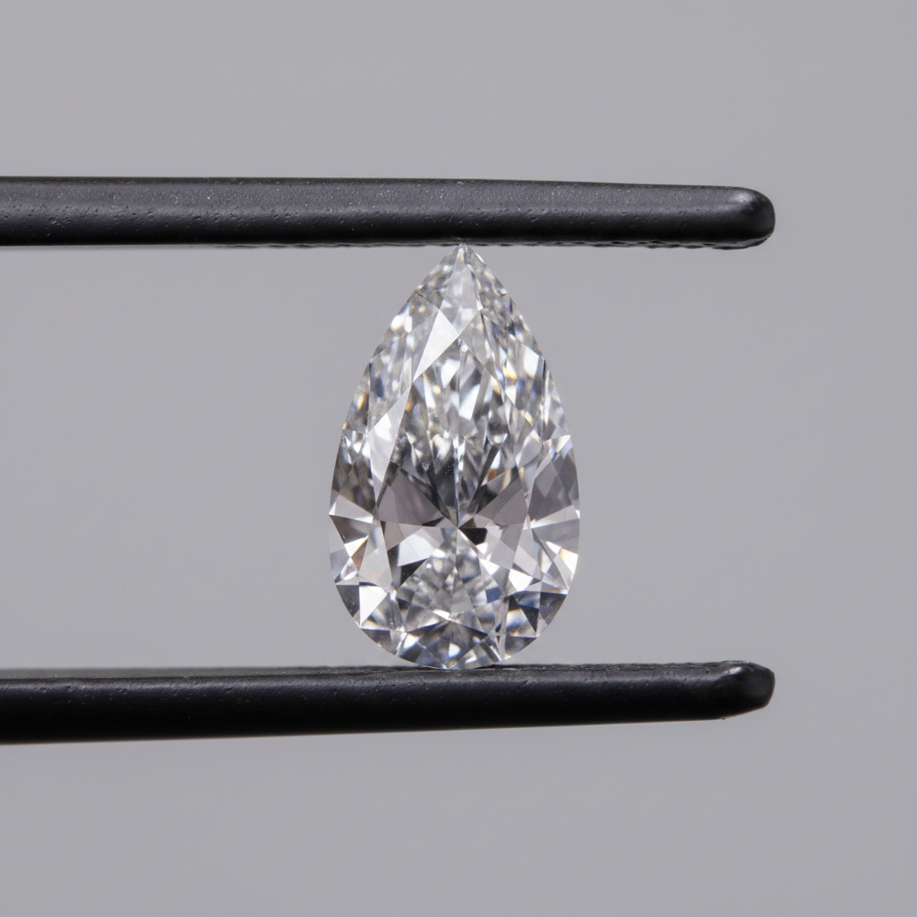 Pear-shaped diamond held between tweezers against a gray background
