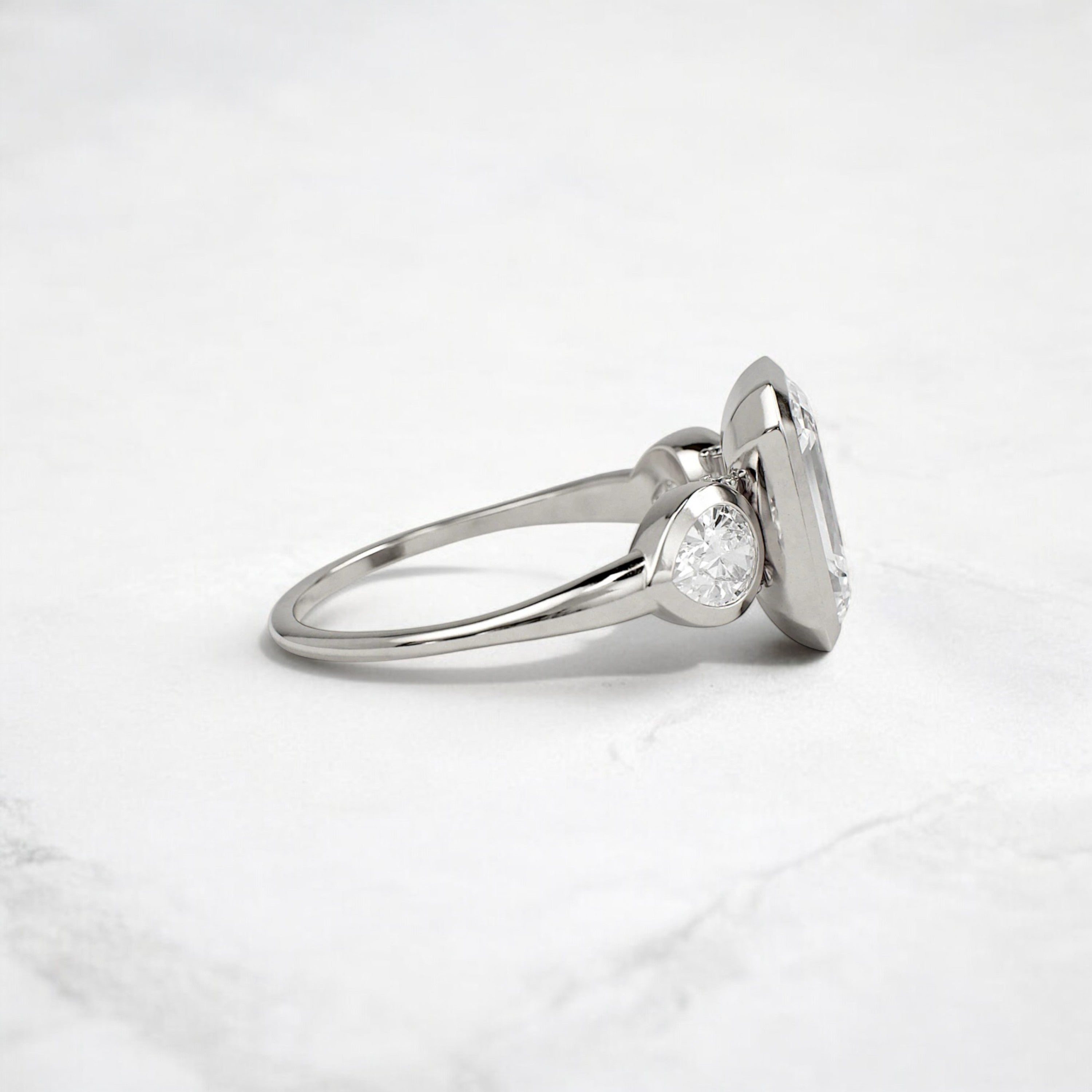 bezel-emerald-moissanite-engagement-ring-pear-side-sparkle-stones-3-ct-platinum-gemfora-3