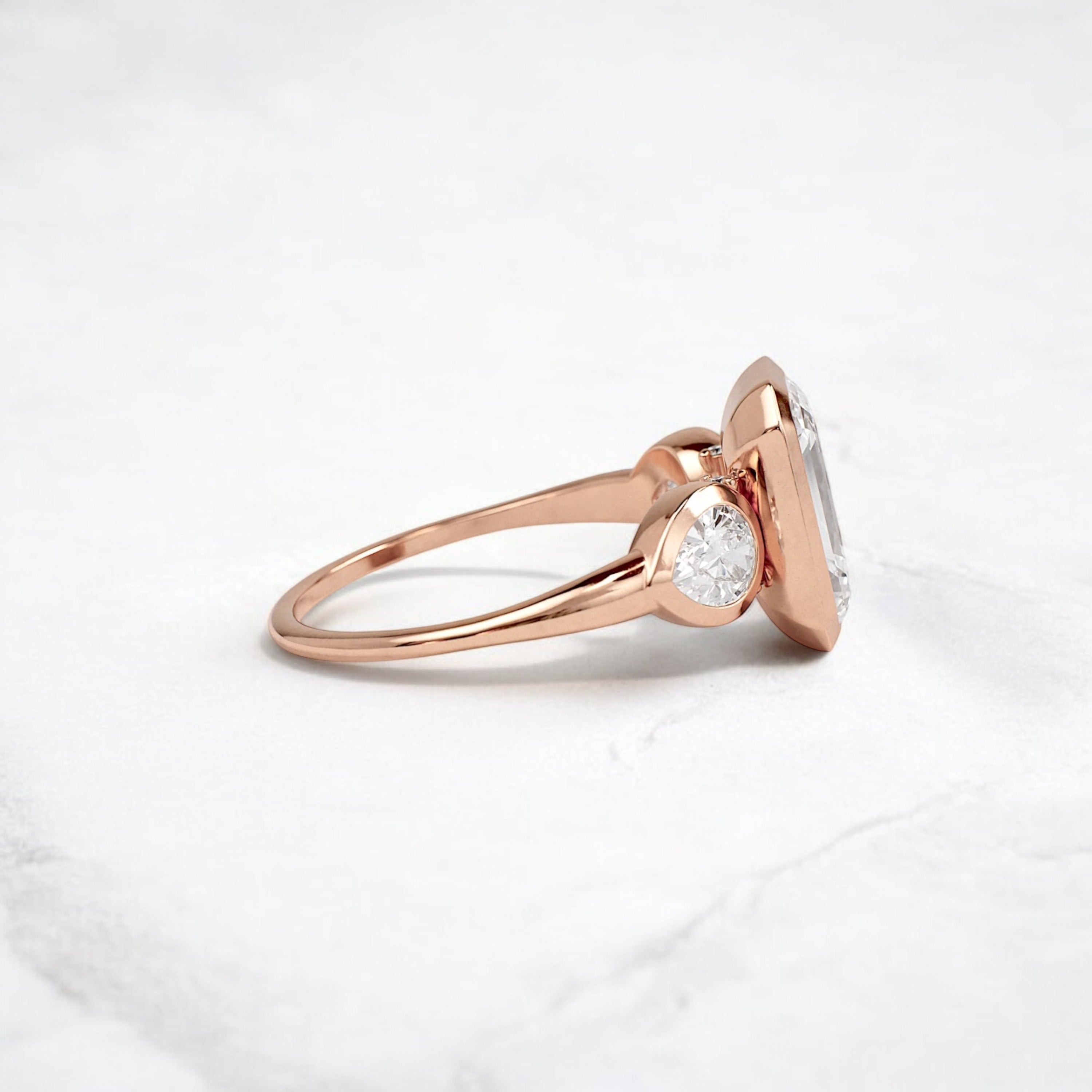 bezel-emerald-moissanite-engagement-ring-pear-side-sparkle-stones-3-ct-rose-gold-gemfora-3