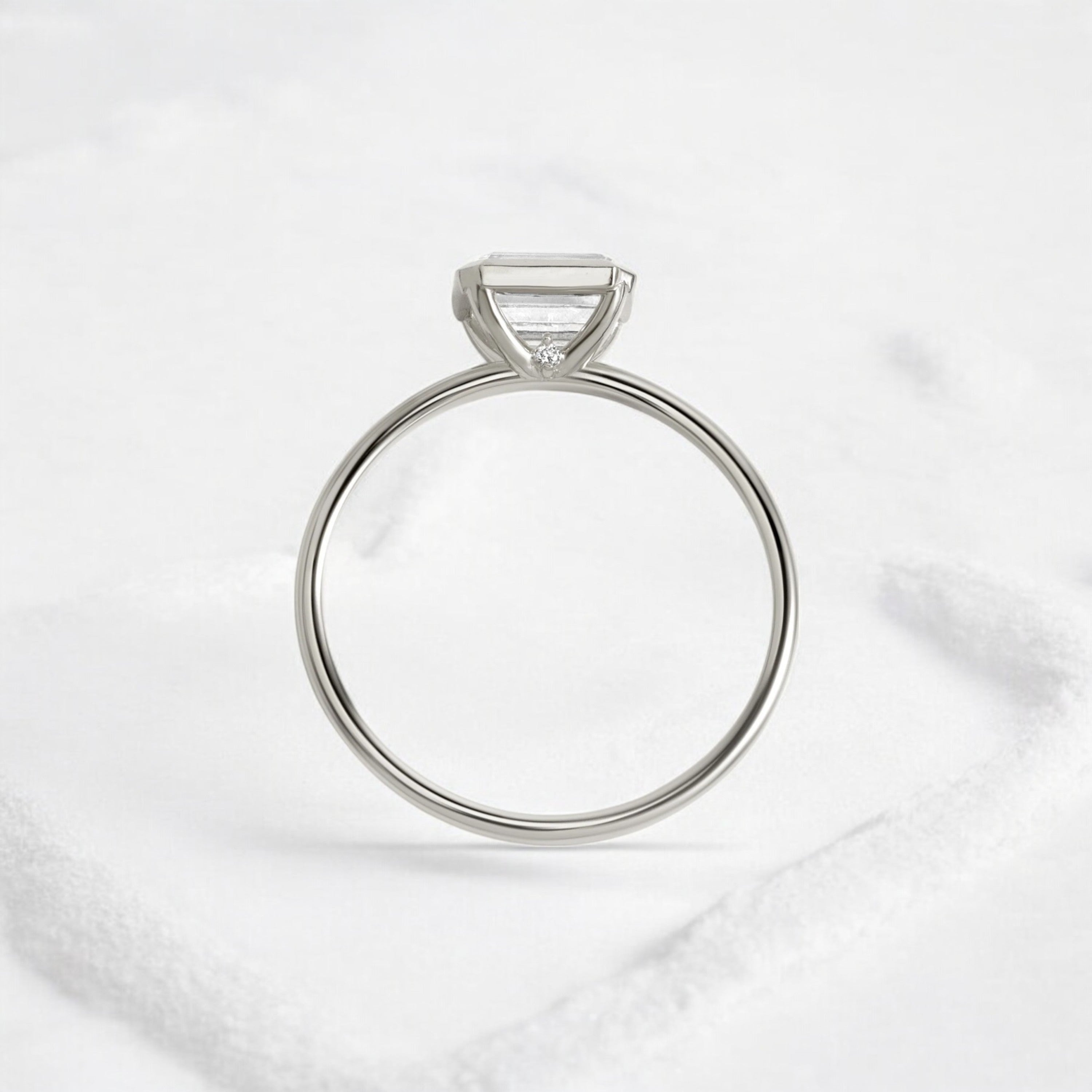 Elegant handmade emerald cut diamond engagement ring, featuring a bezel setting designed for women.