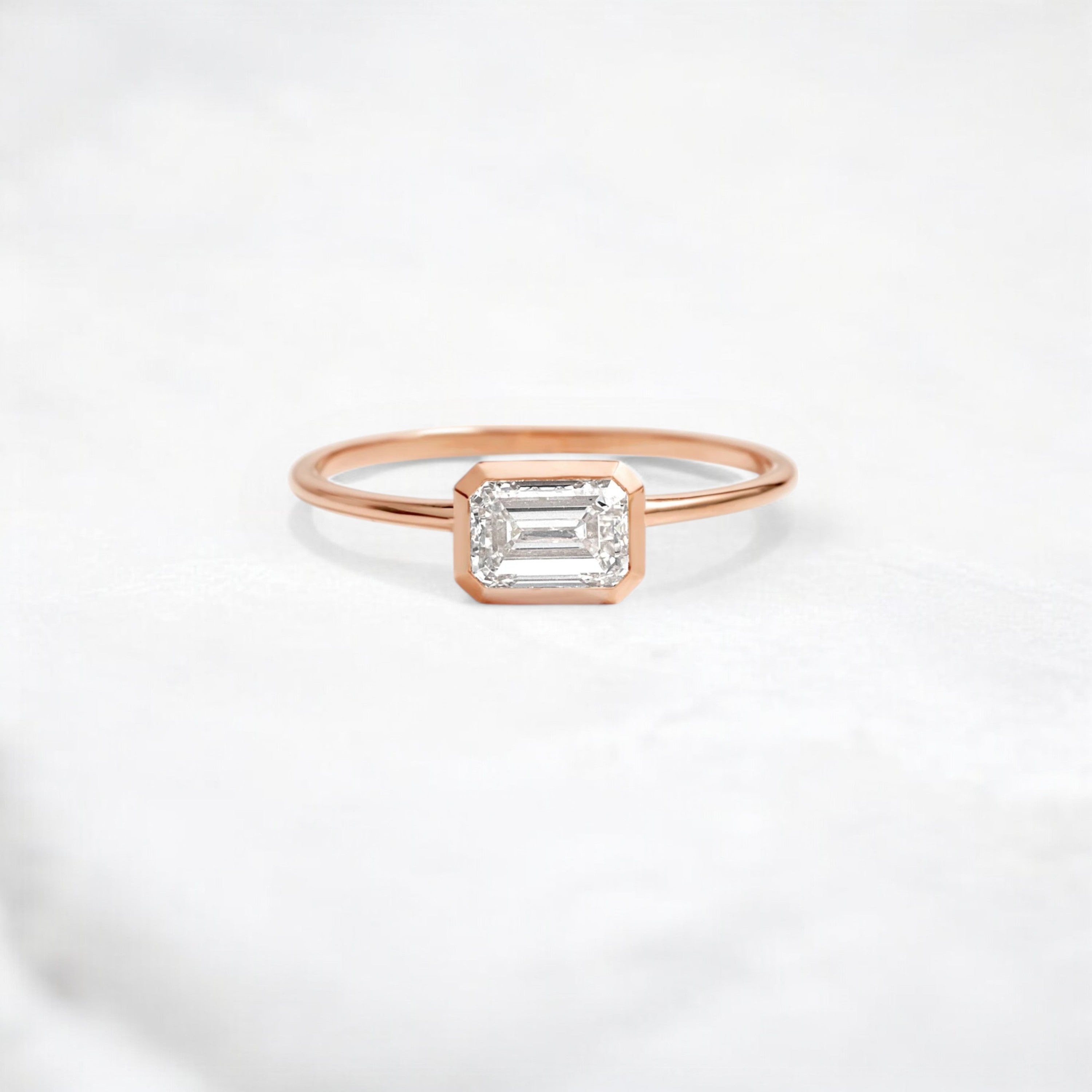 Elegant handmade emerald cut diamond engagement ring, featuring a bezel setting designed for women.