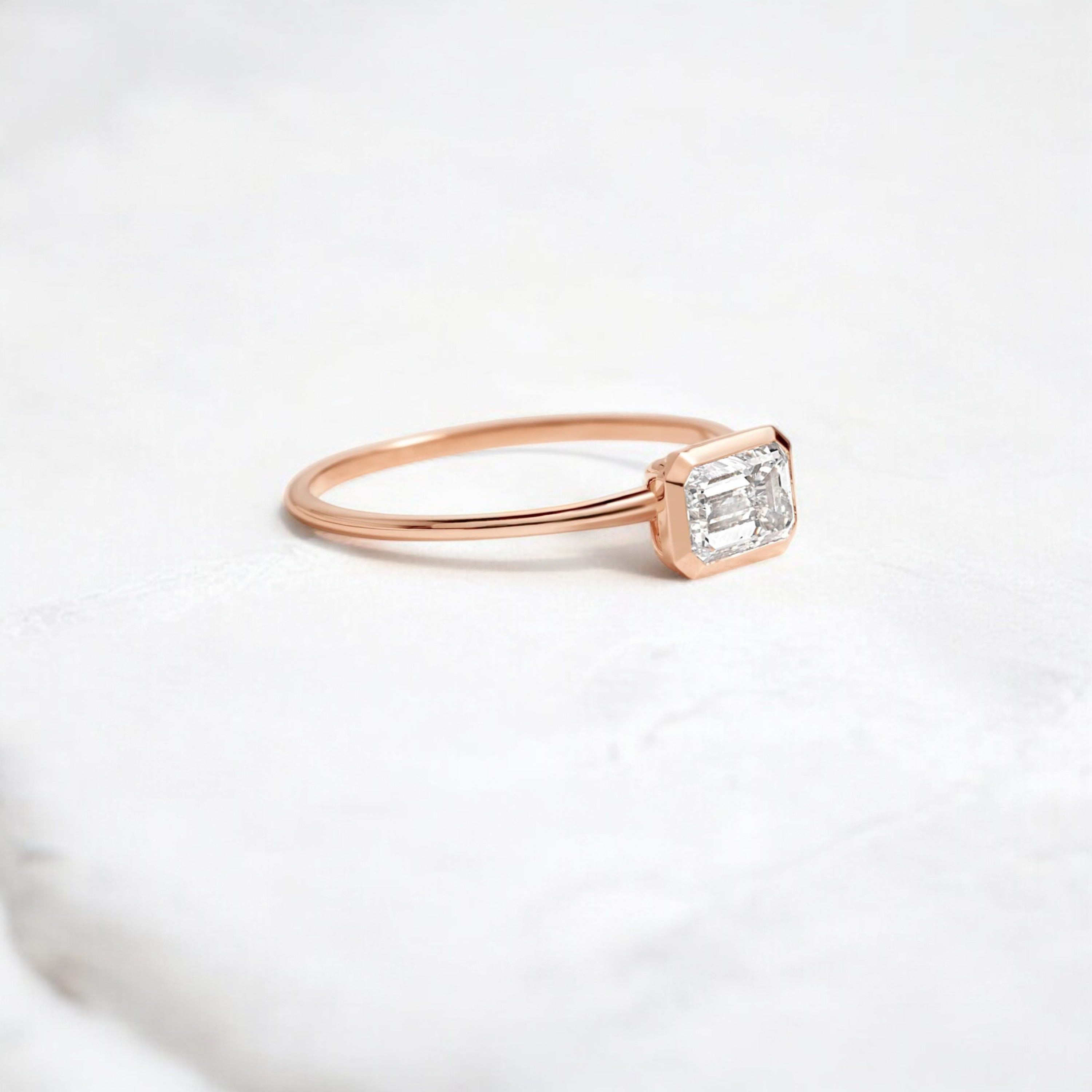 Elegant handmade emerald cut diamond engagement ring, featuring a bezel setting designed for women.