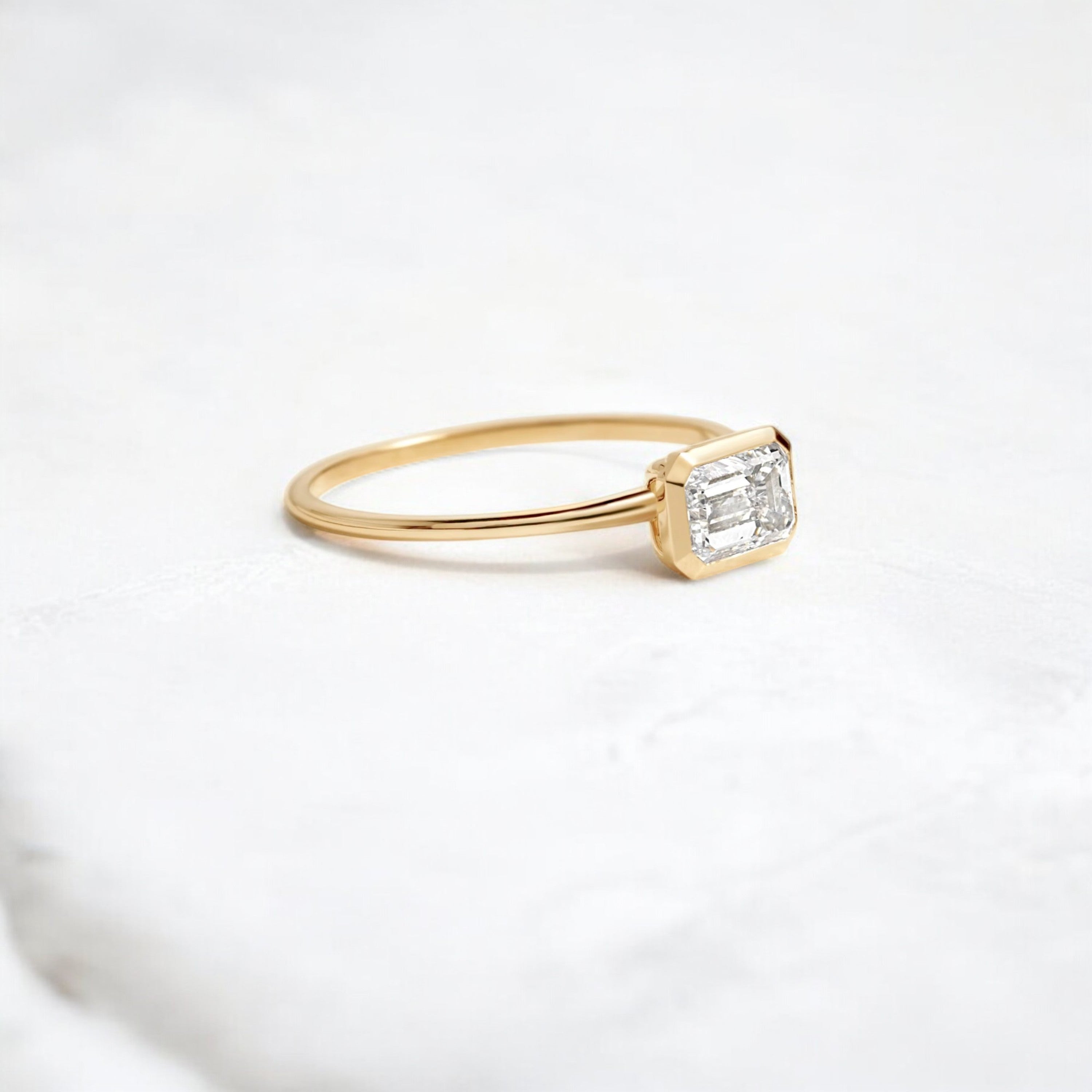 Elegant handmade emerald cut diamond engagement ring, featuring a bezel setting designed for women.