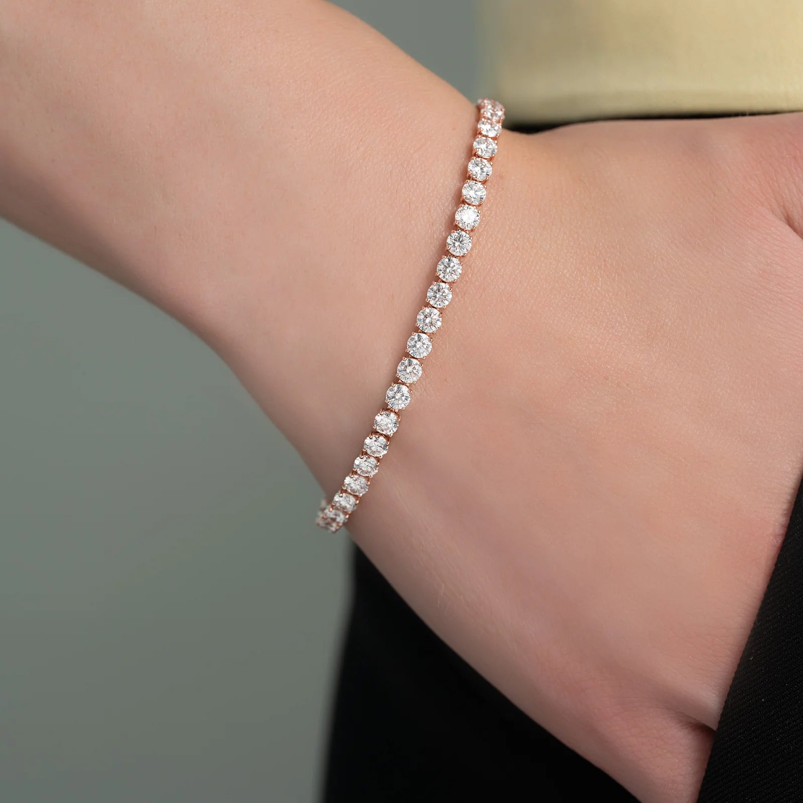 Diamond bracelet on a person's wrist against a neutral background