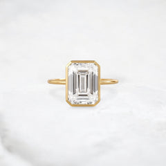 secret-glimmer-emerald-cut-bezel-moissanite-engagement-ring-4-ct-yellow-gold-gemfora-1